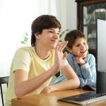 younger students looking at laptop