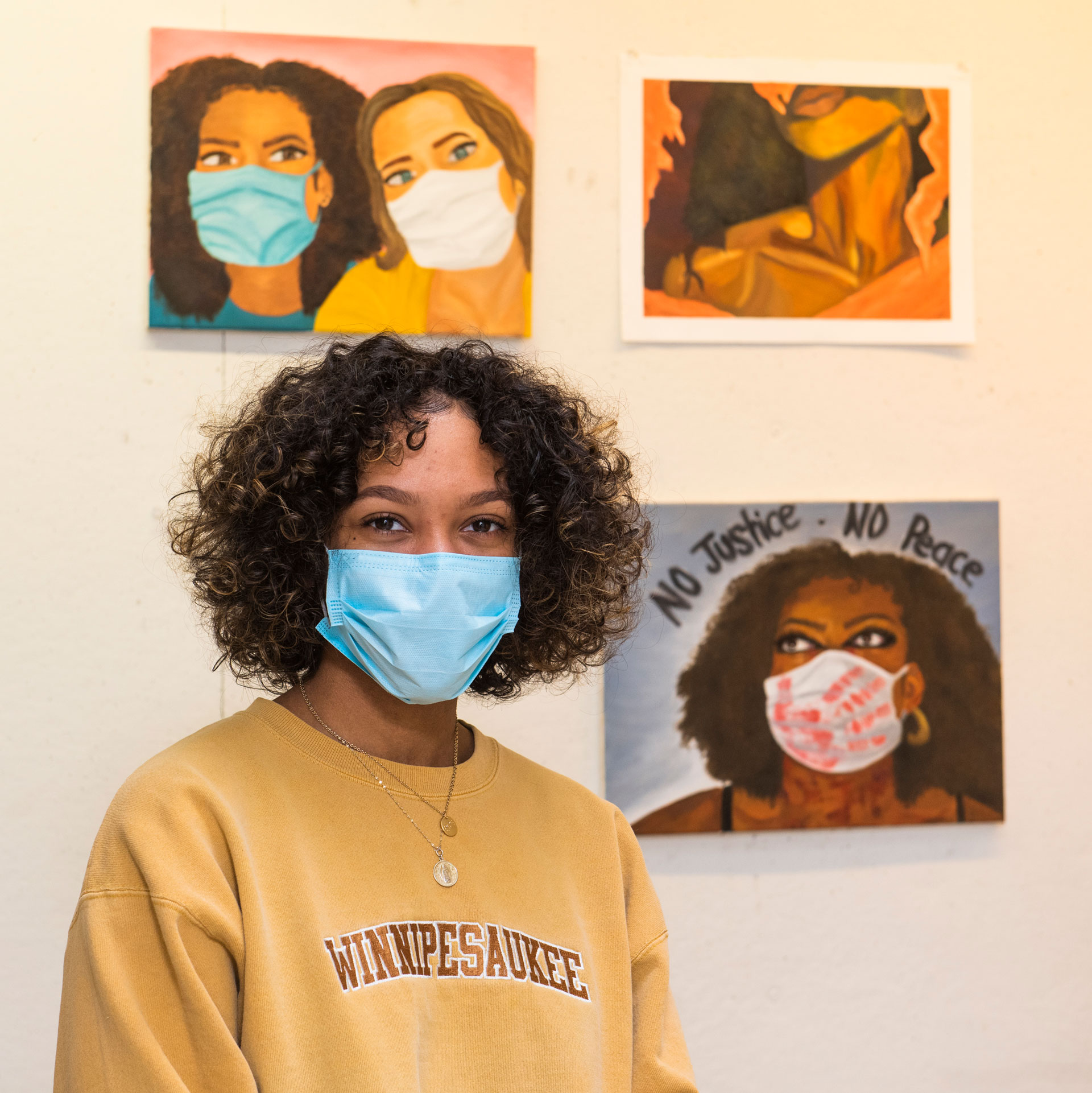 portrait of SCSU student artist Ryana Kelsey with her work