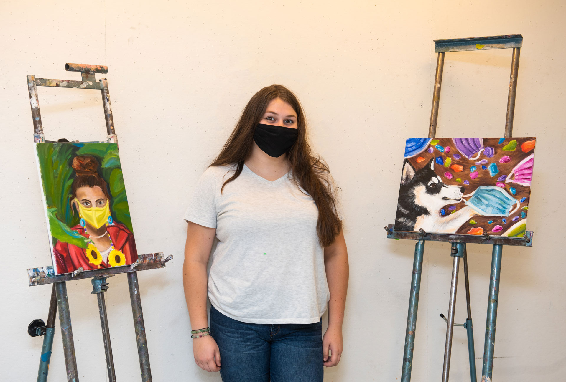 portrait of SCSU student artist Isabelle Reina with her work