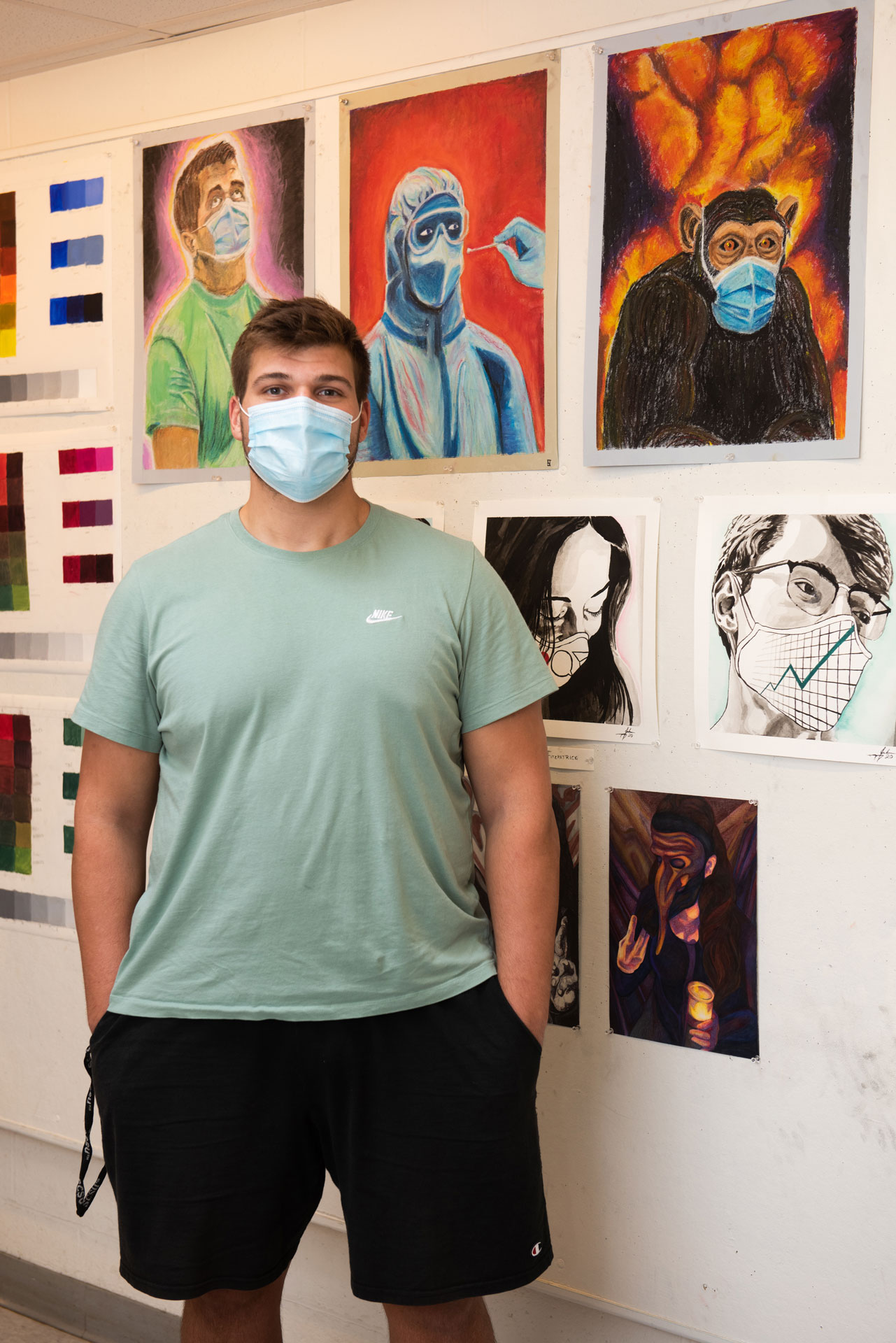 portrait of SCSU student artist Nathan Shilling with his work