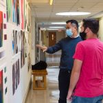 SCSU art professor Thuan Vu reviewing student artwork in Earl Hall