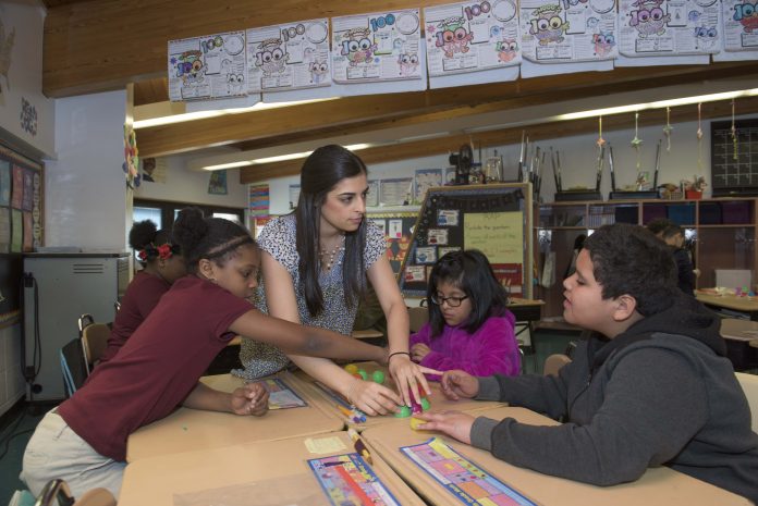 a student teacher works with her students in the classroom