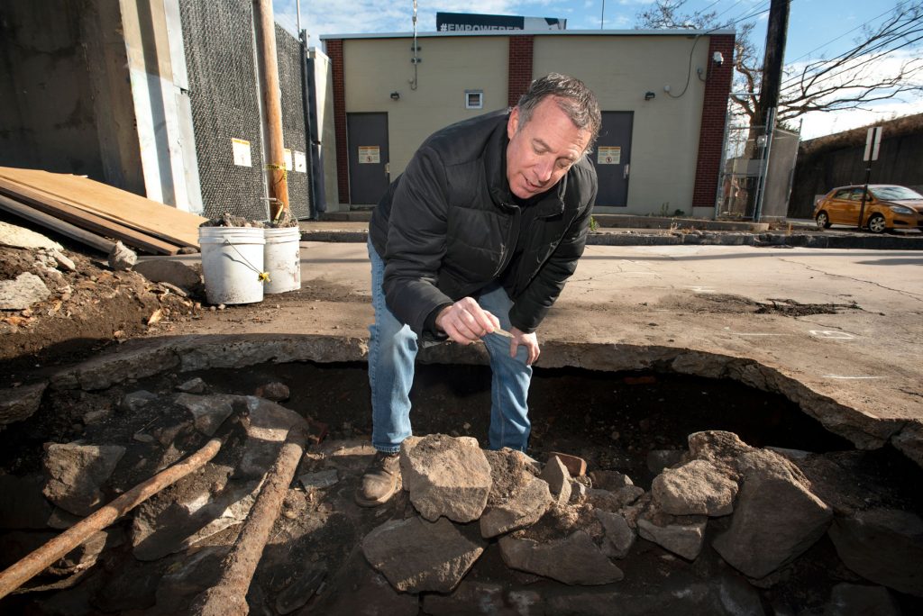 Local historian Robert S. Greenberg examines pottery found at the site of Benedict Arnold’s New Haven home in December 2021.