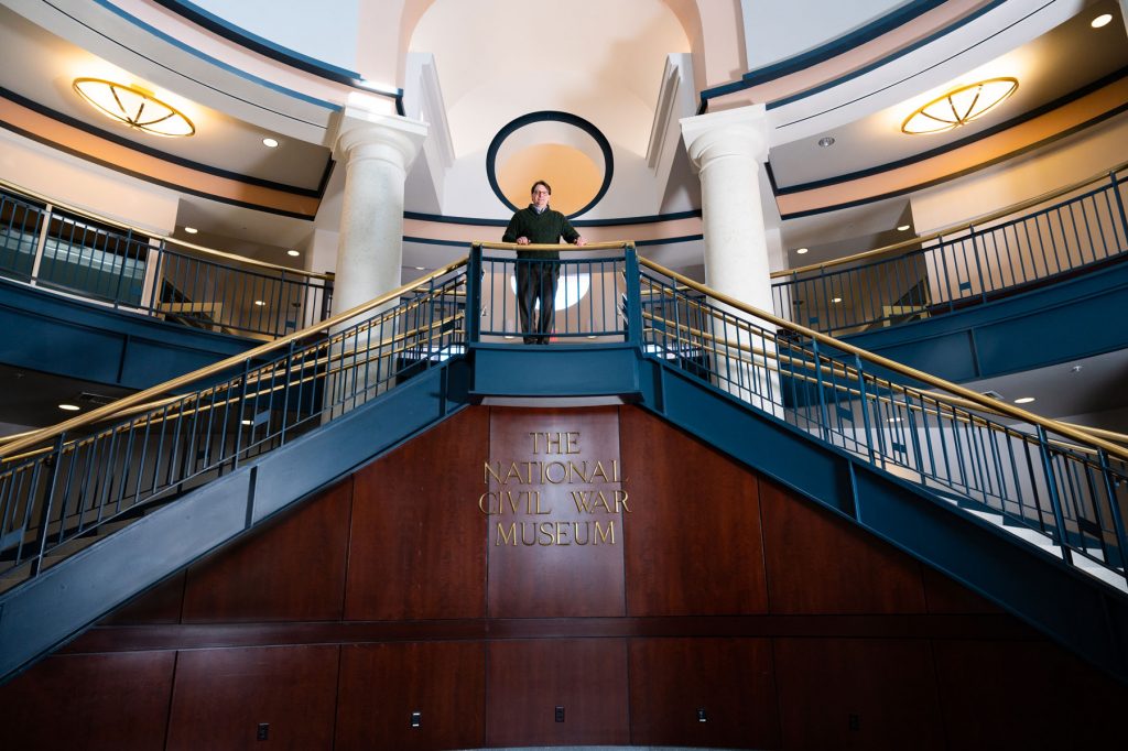 Jeffrey Nichols, '96, stands on the main staircase of the National Civil War Museum, which includes two floors of galleries.