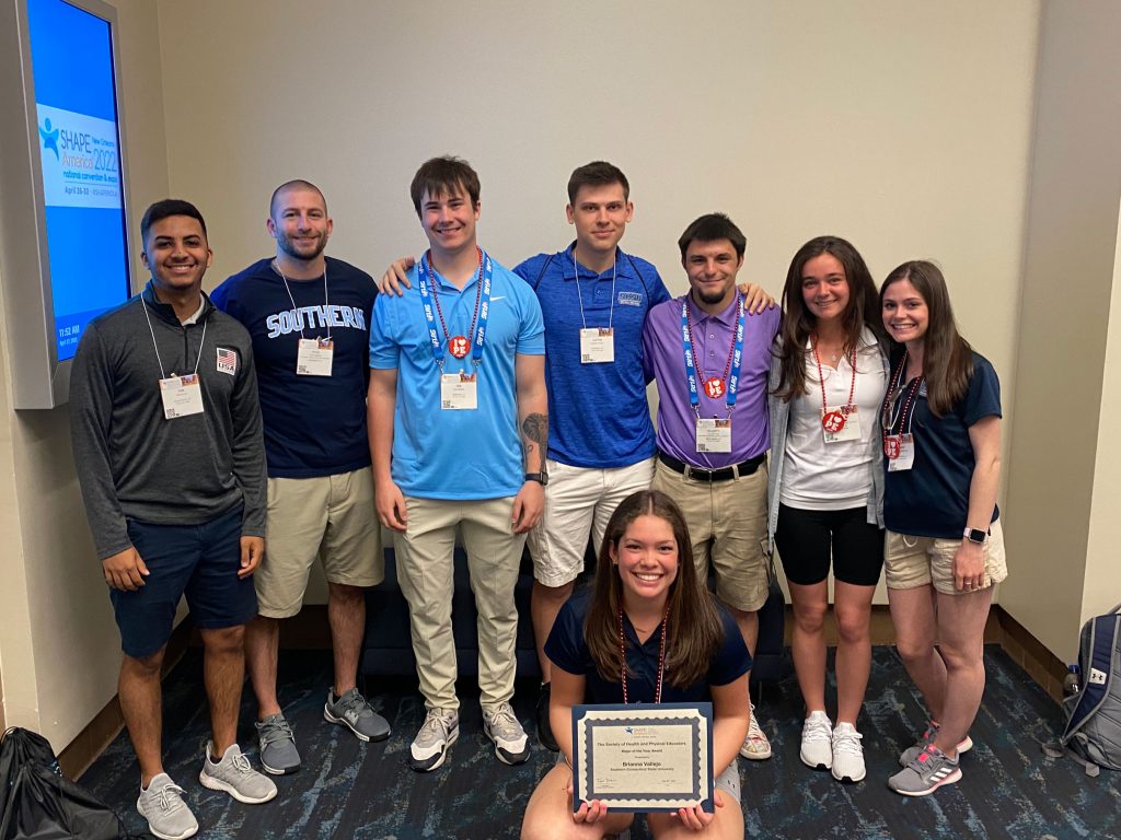 SCSU students attend the 2022 Society of Health and Physical Educators conference: Yan Soares-Silva, Class of 2022; Kyle Menta, Class of 2022; Ian Agnew, Junior; Justin Longo, Junior; Elliott Via, Junior; Peri Combs, Junior; Lianne Iassogna, Class of 2022; (kneeling) Brianna Vallejo, Class of 2022