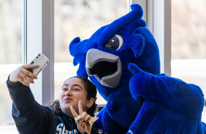 A student takes a selfie with Otus the Owl