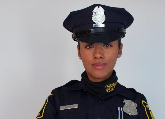 A woman in a police officer uniform standing in front of a white background