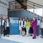 staffers standing around a banner