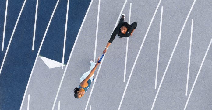 Photographed on Southern's track, the Olympic champion takes the baton from her mother — Dawn Stanton, '90, M.S. '97, the director of University Access Programs at Southern