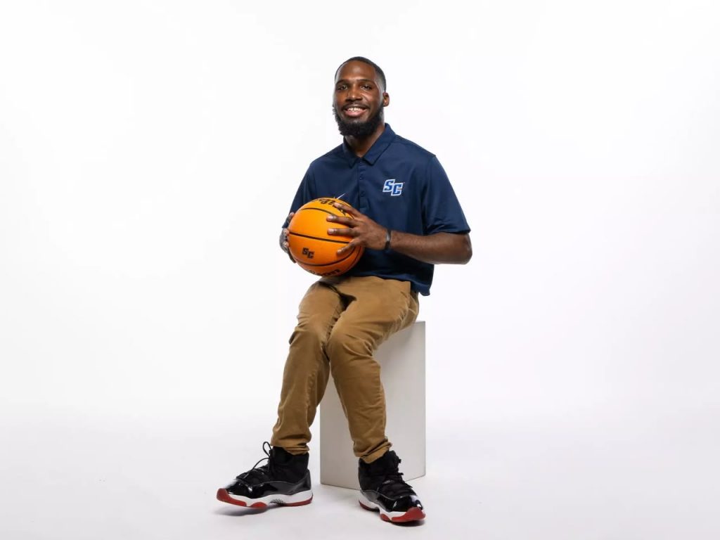 Senior Dejon Knight holds a basketball, illustrating his contributions to the team.