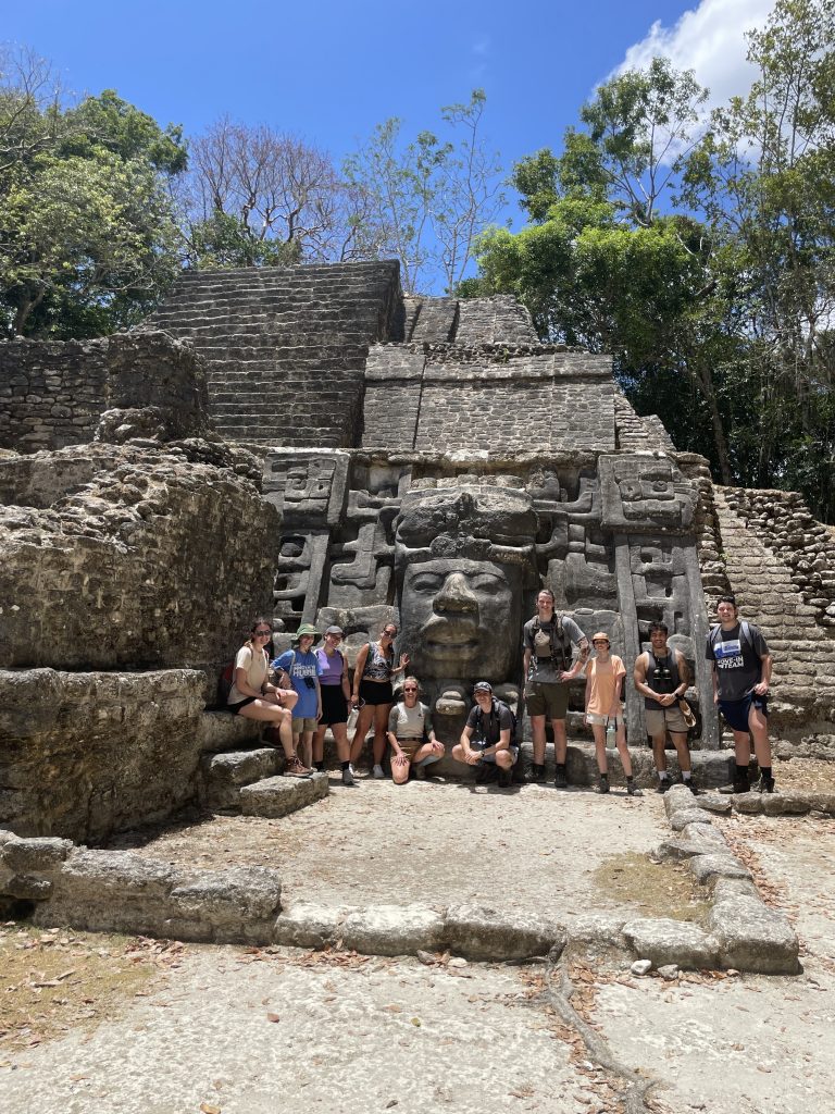 Students and professor pose on a stone temple.