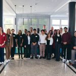 A group of students and faculty from Southern Connecticut State University and the University of Applied Sciences South Westphalia stand together indoors, smiling for a group photo during their COIL Plus collaboration in Soest, Germany.