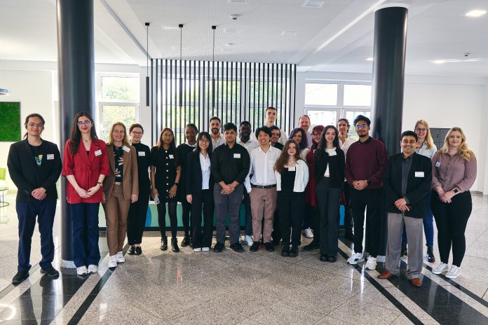 A group of students and faculty from Southern Connecticut State University and the University of Applied Sciences South Westphalia stand together indoors, smiling for a group photo during their COIL Plus collaboration in Soest, Germany.