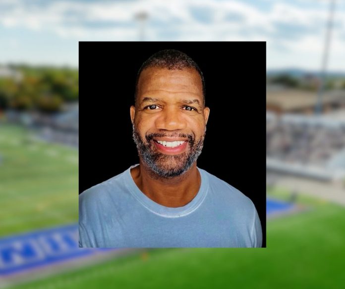 Rob Parker, a 1986 Southern Connecticut State University graduate and national sports analyst, smiling against a black background, with a blurred football field in the backdrop.