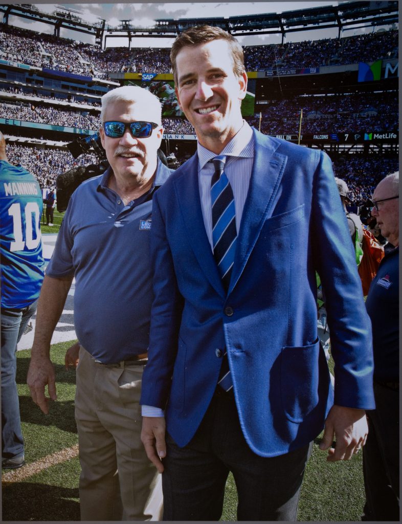 Two men stand in the middle of the stadium, surrounded by a huge crowd.