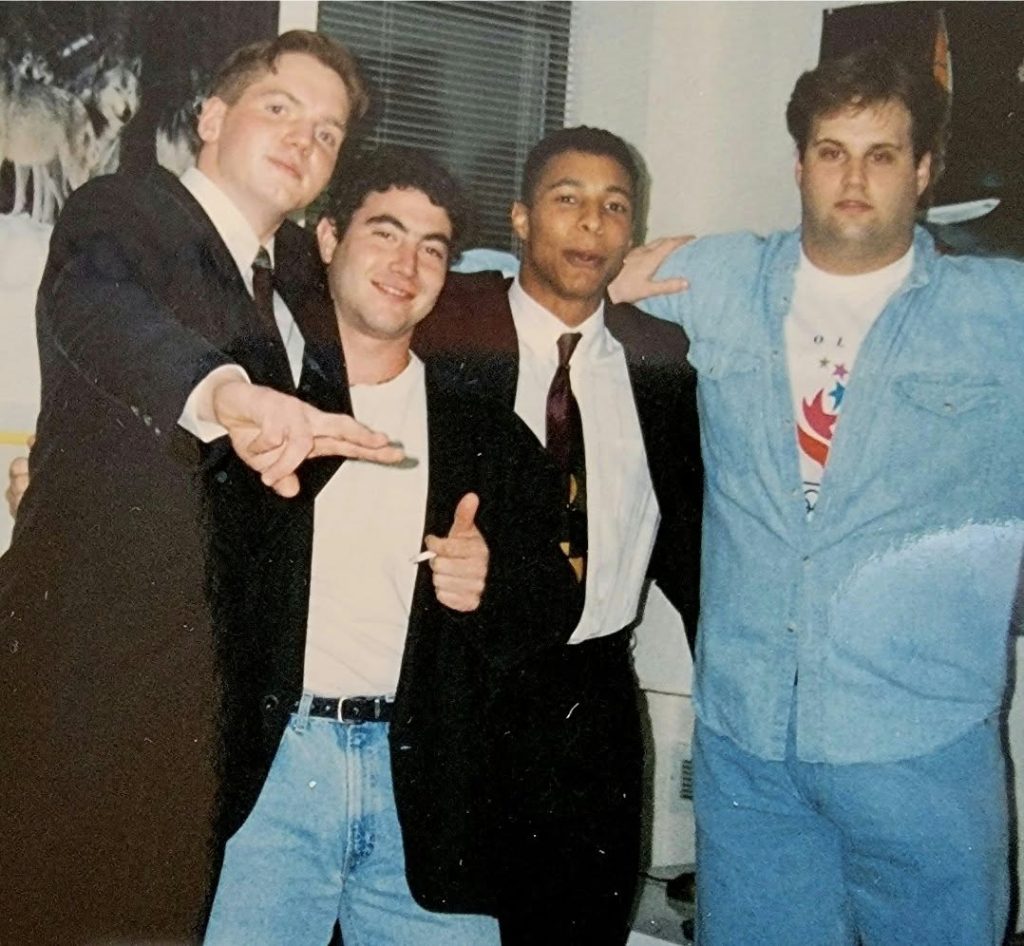 Four Southern students pose together with their arms around one another during their college years, some dressed in jackets and ties.